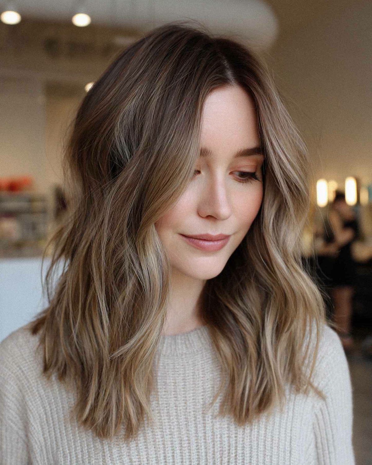 18 Medium Length Curly Hair Hairstyles, From Bobs to Shags 9 Woman with medium-length light brown hair styled in loose, relaxed beachy waves.