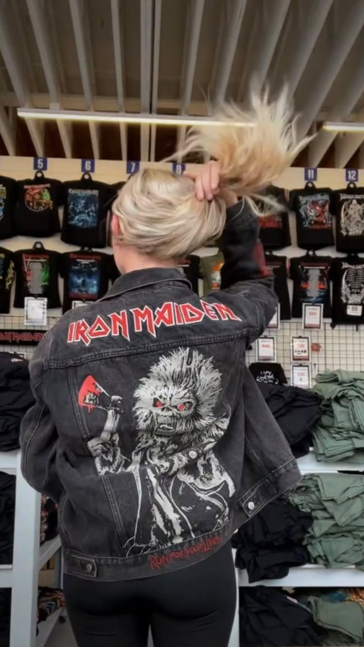 Metal Festival Outfit Ideas for Women: 10 Bold Looks to Try 10 Woman wearing a black Iron Maiden denim jacket and leggings in a clothing store