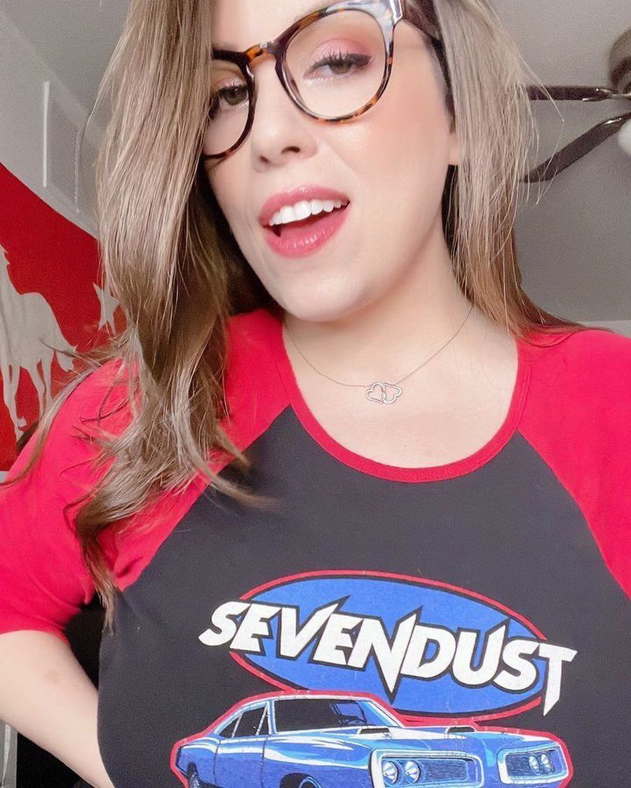 Metal Festival Outfit Ideas for Women: 10 Bold Looks to Try 2 Woman wearing a Sevendust band t-shirt with a blue car graphic.