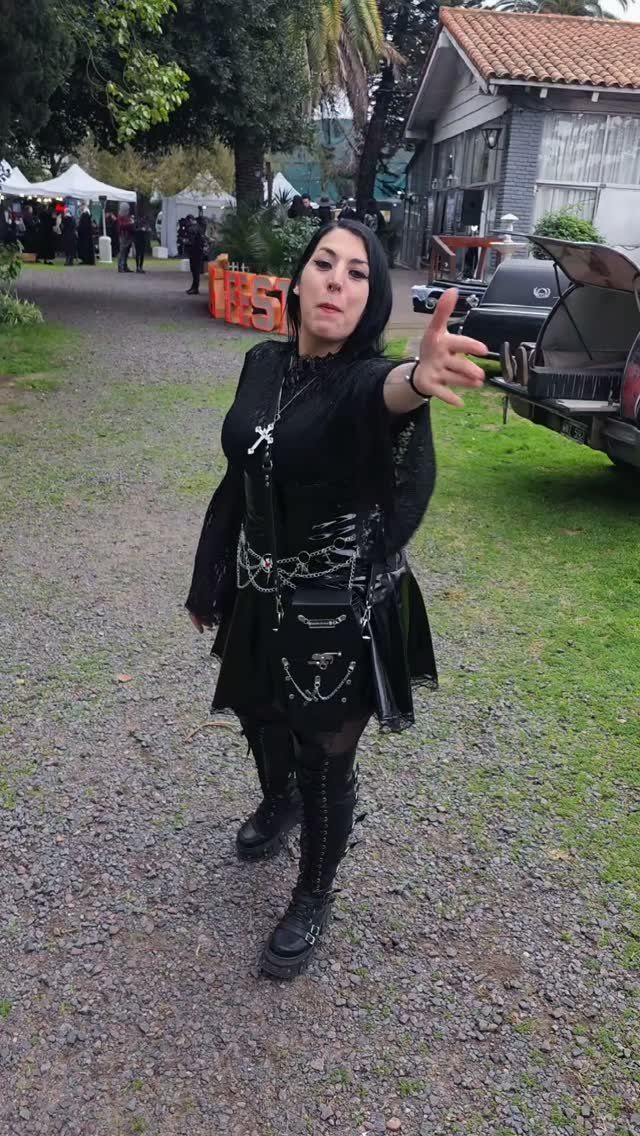 Metal Festival Outfit Ideas for Women: 10 Bold Looks to Try 6 Woman in a black gothic dress with silver chains and platform combat boots.