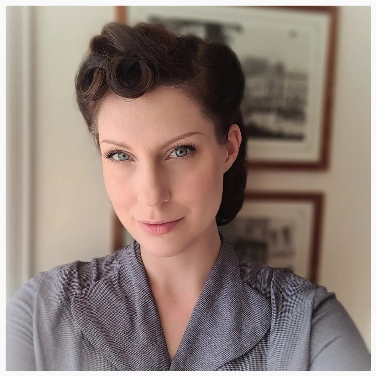 Pin Up Curls Hairstyles: 7 Ideas From Victory Rolls to Bows 5 Woman with vintage pin up curls and a grey blazer posing for a portrait.
