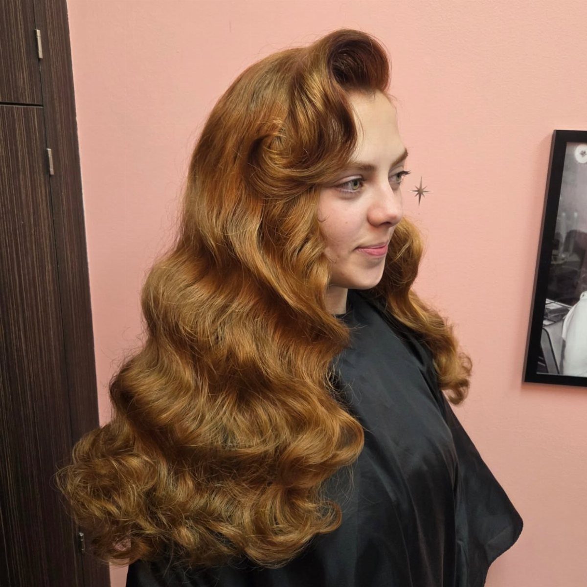 Pin Up Curls Hairstyles: 7 Ideas From Victory Rolls to Bows 4 Woman with long reddish-brown hair styled in voluminous vintage waves and curls.