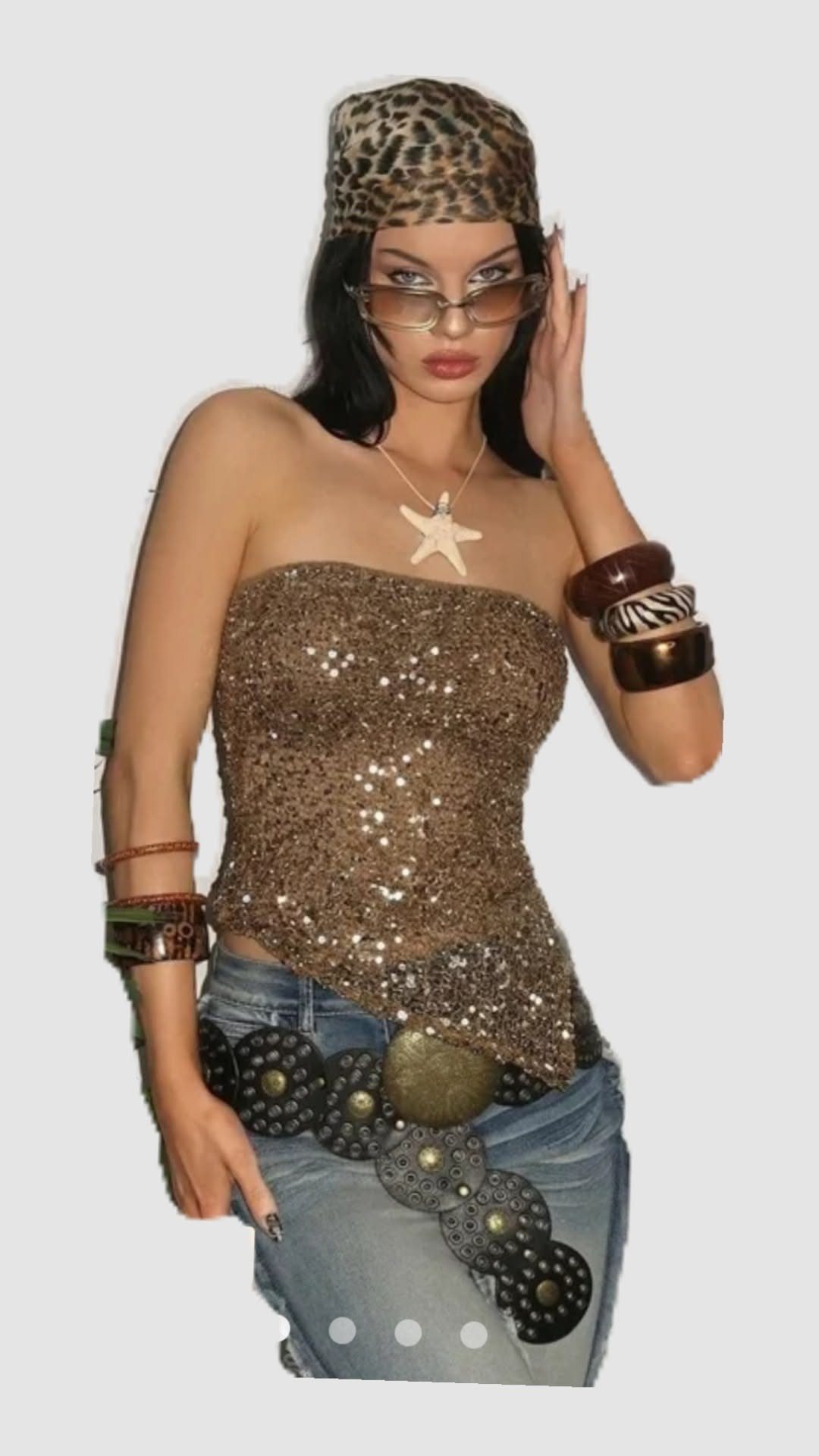 Woman wearing a gold sequin tube top, leopard print headwrap, and blue jeans.