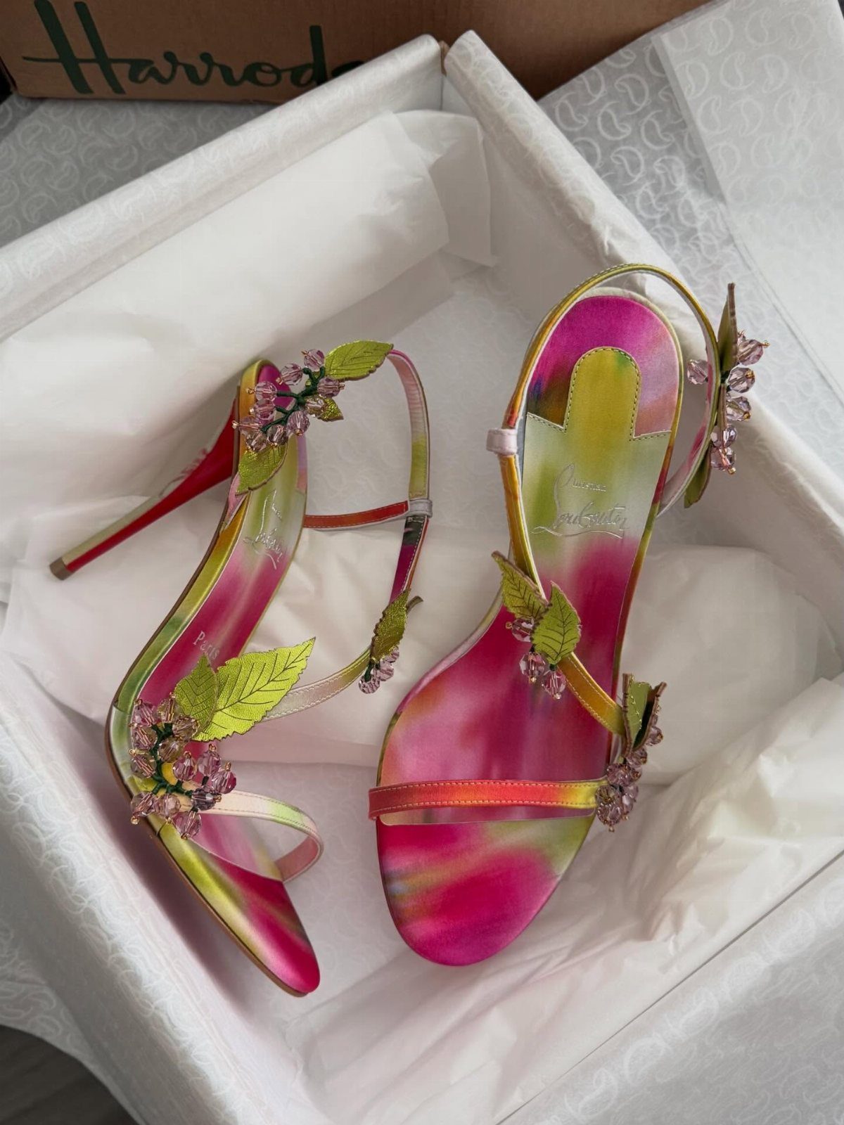 Colorful gradient high-heeled sandals with floral decorations inside a white shoebox
