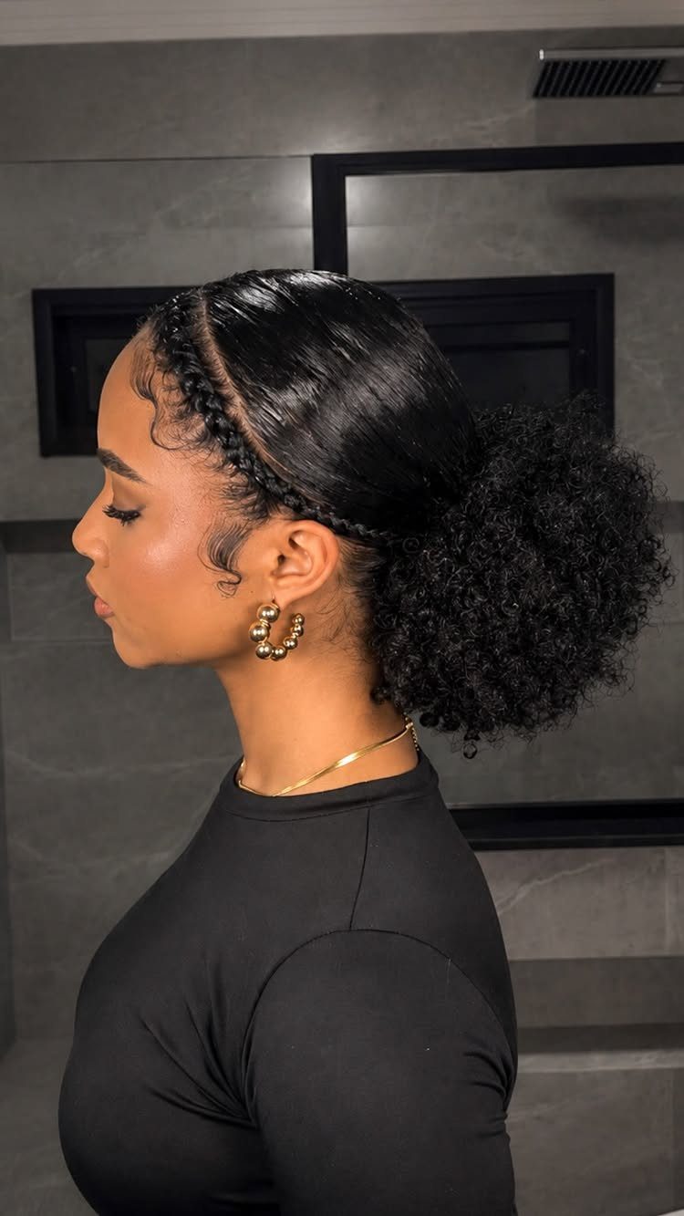 Woman with side cornrows leading into a large, curly high puff hairstyle.