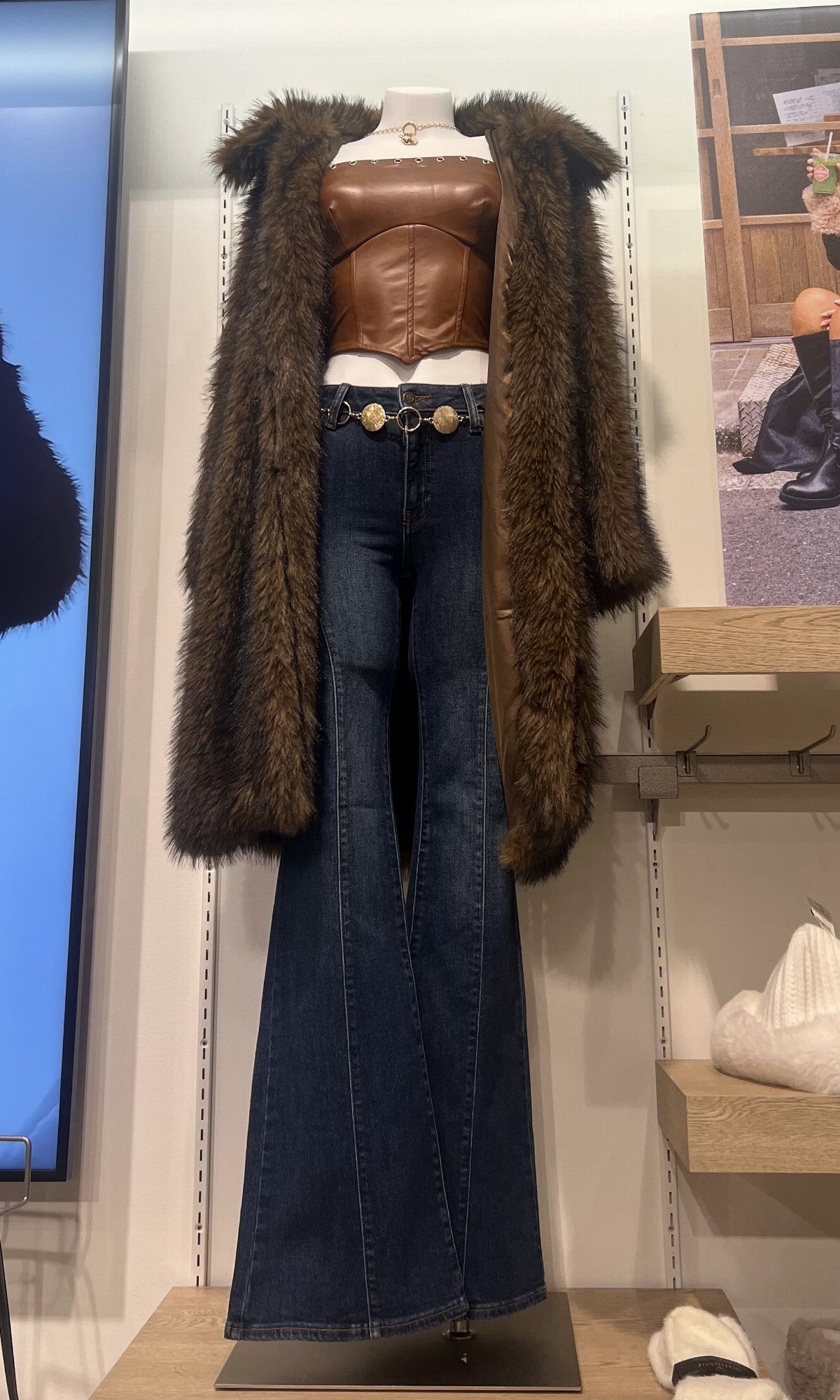29 Rodeo Inspired Outfits Built on Fringe, Denim, and Boots 25 Brown faux-fur trimmed coat and dark blue flare jeans on a mannequin.