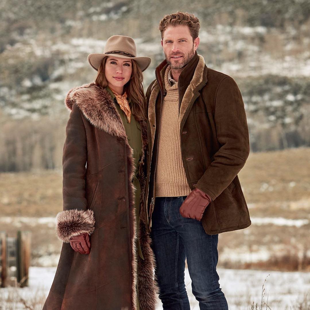 29 Rodeo Inspired Outfits Built on Fringe, Denim, and Boots 24 Man and woman wearing brown shearling jackets and jeans in a snowy field.