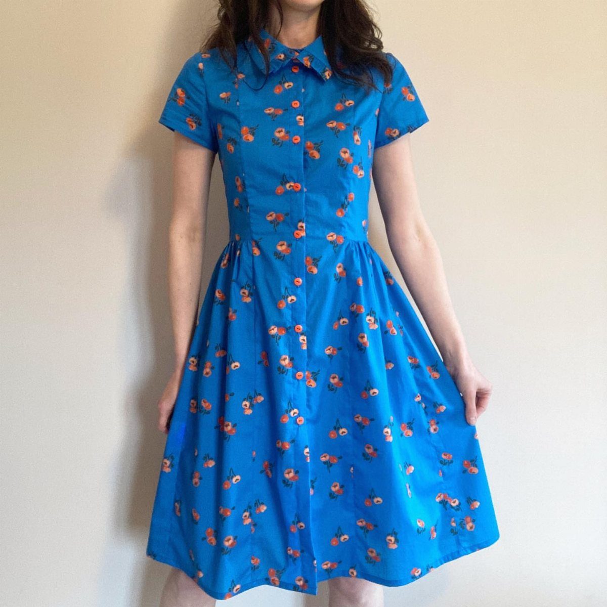 Semi Casual Clothes: 31 Outfit Ideas From Dresses to Loafers 2 Person wearing a blue knee-length dress with orange floral patterns and a bow collar.