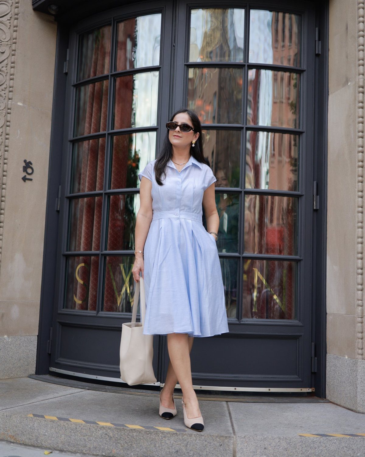 Semi Casual Clothes: 31 Outfit Ideas From Dresses to Loafers 23 Woman in a light blue shirt dress and heels standing before glass doors.