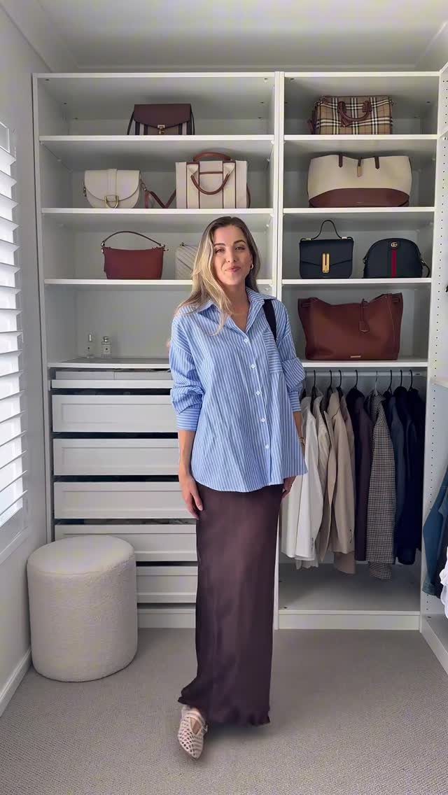 Semi Casual Clothes: 31 Outfit Ideas From Dresses to Loafers 30 Woman wearing a blue striped shirt and a long brown satin skirt in a closet.