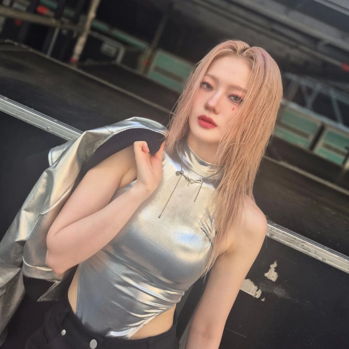 12 Seventeen Concert Outfit Ideas for Women to Stand Out 3 Woman wearing a metallic silver sleeveless top and matching silver jacket.