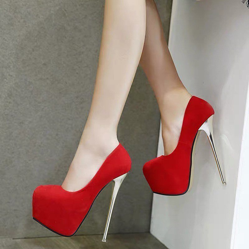 Red suede platform high heels with gold metallic stiletto heels on a person.