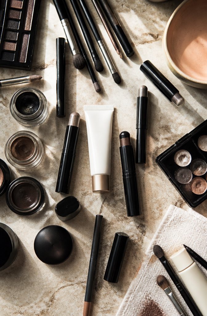 Makeup products including Revlon primer and cream shadow sticks on display.