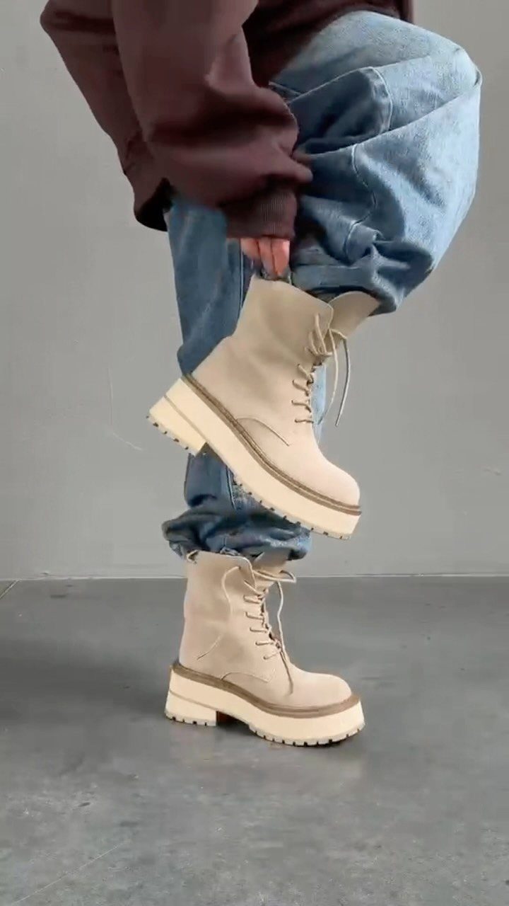 Beige chunky platform boots paired with wide-leg light-wash blue jeans and brown sweatshirt.