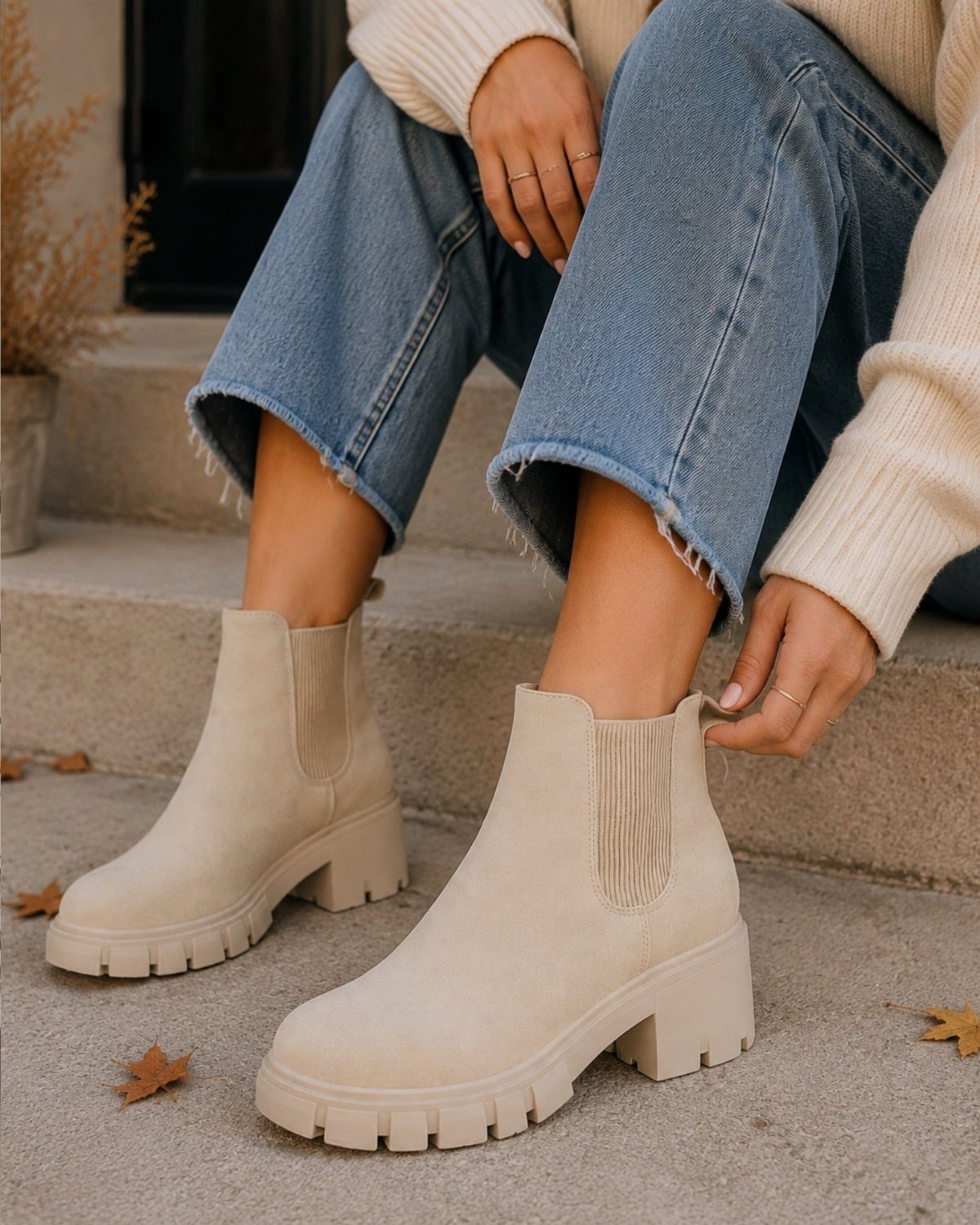 Light-wash wide-leg jeans paired with tan chunky Chelsea boots on concrete steps.