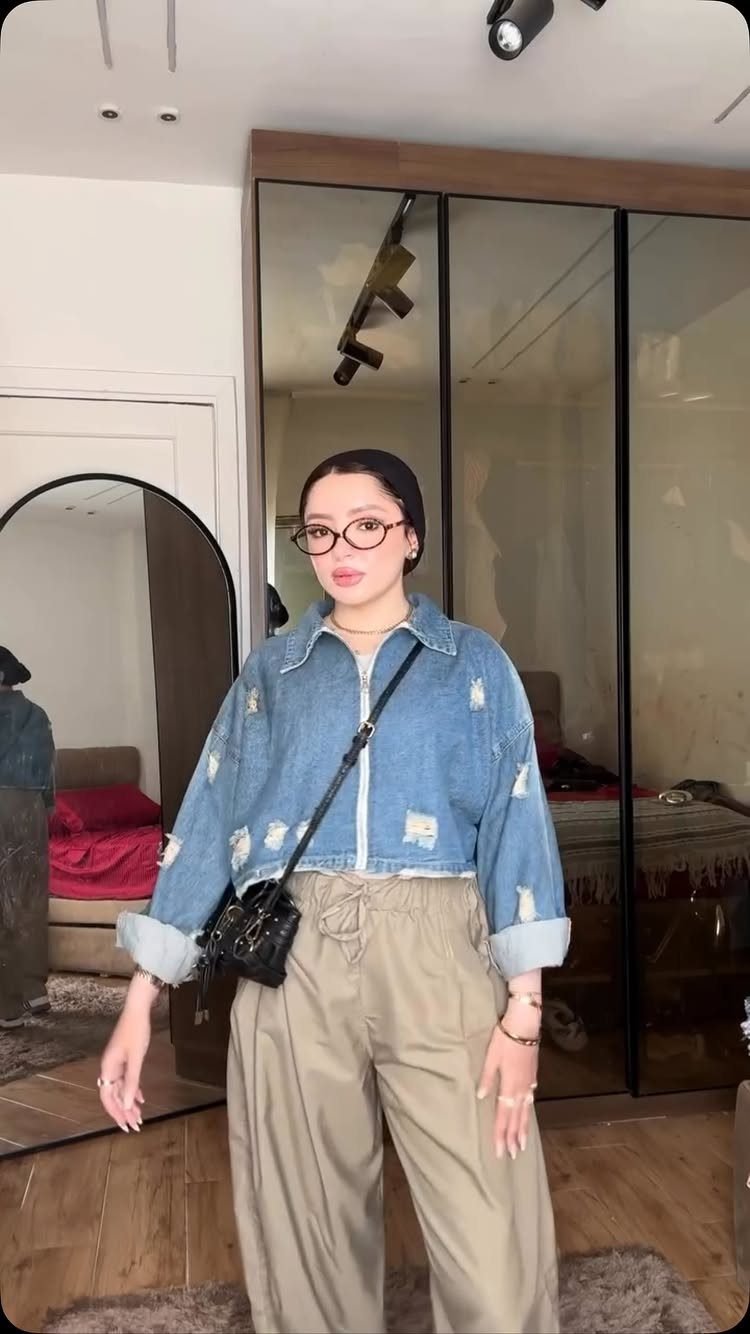 Tan Linen Pants Outfit Ideas for Women: 11 Looks to Try 9 Woman in a distressed denim jacket and tan wide-leg linen pants posing indoors.