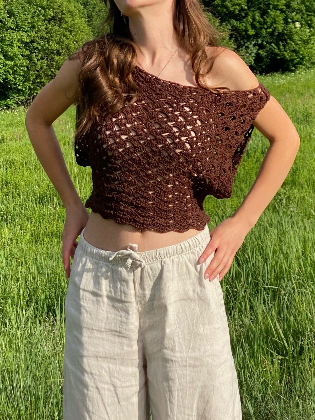 Tan Linen Pants Outfit Ideas for Women: 11 Looks to Try 6 Woman wearing a brown crochet knit top and tan wide-leg linen pants in grass.