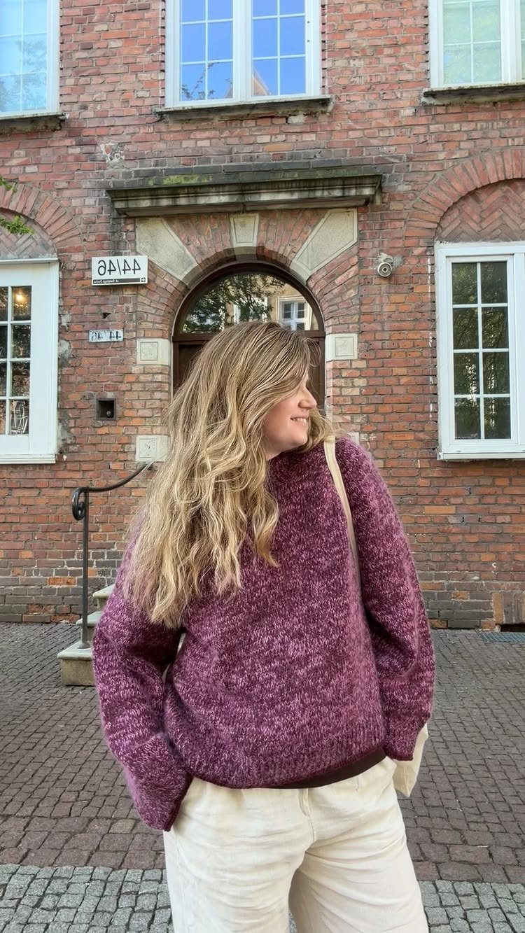 Tan Linen Pants Outfit Ideas for Women: 11 Looks to Try 8 Woman wearing a purple knit sweater and off-white linen pants before a brick building.
