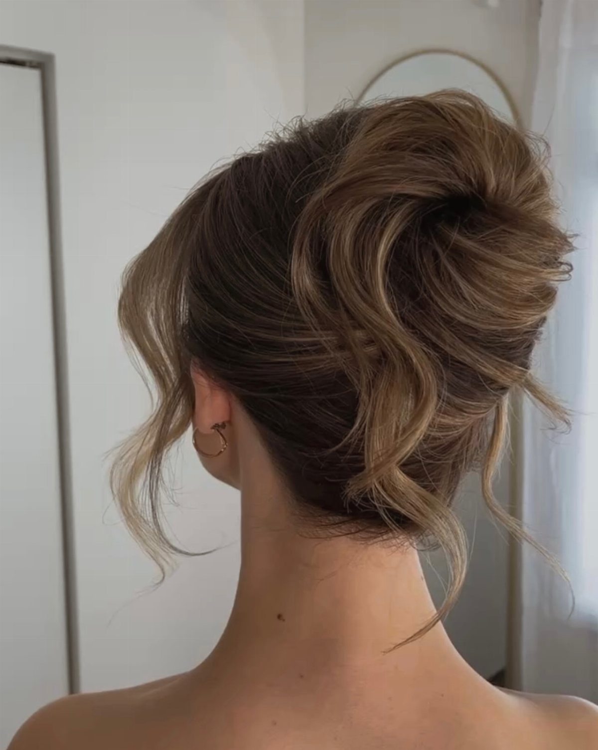 Wavy blonde and brown updo gathered into a loose, voluminous bun.