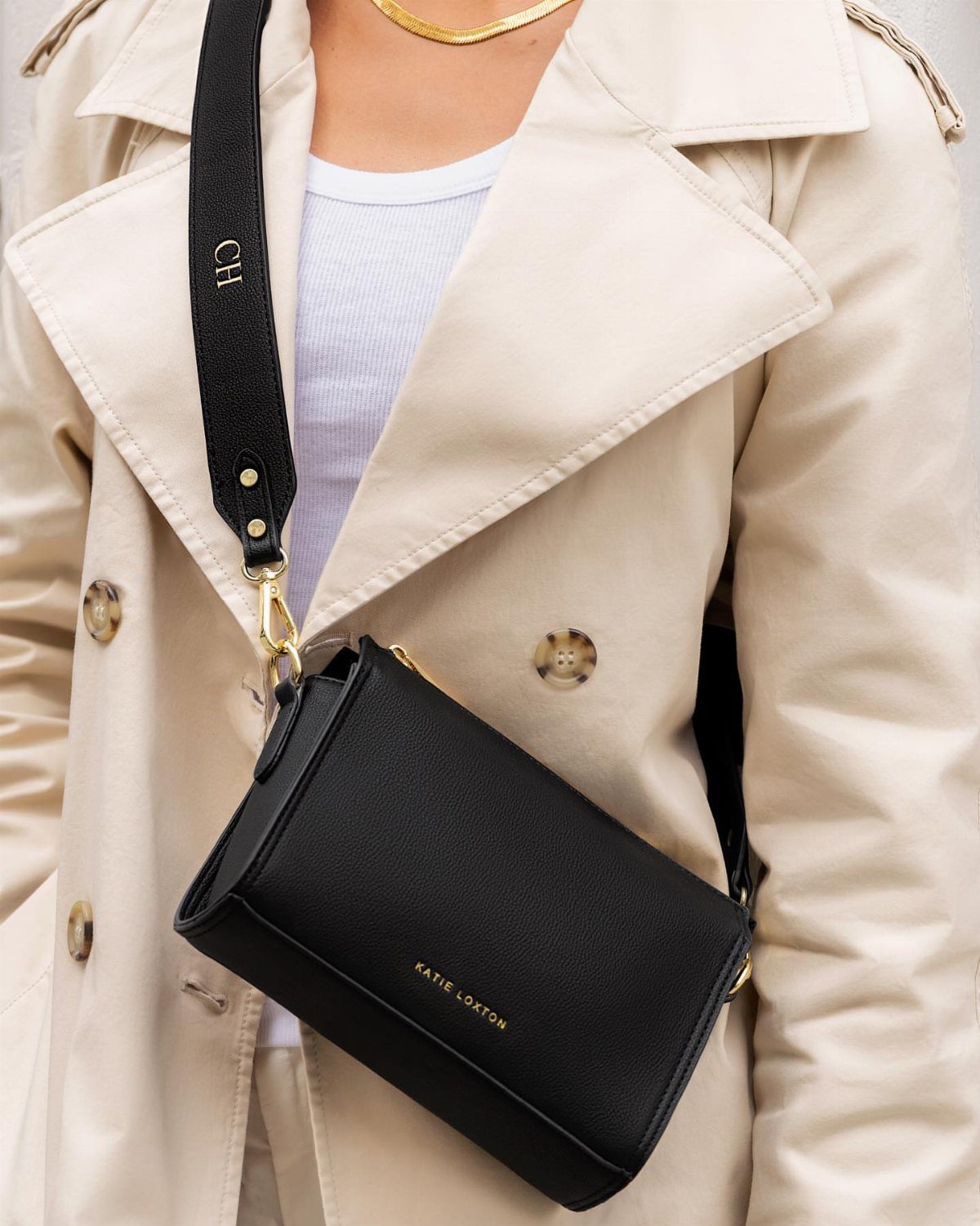 What to Wear on Broadway: 12 Ideas From Blazers to Skirts 7 Small black leather crossbody bag with wide strap worn over a beige trench coat.
