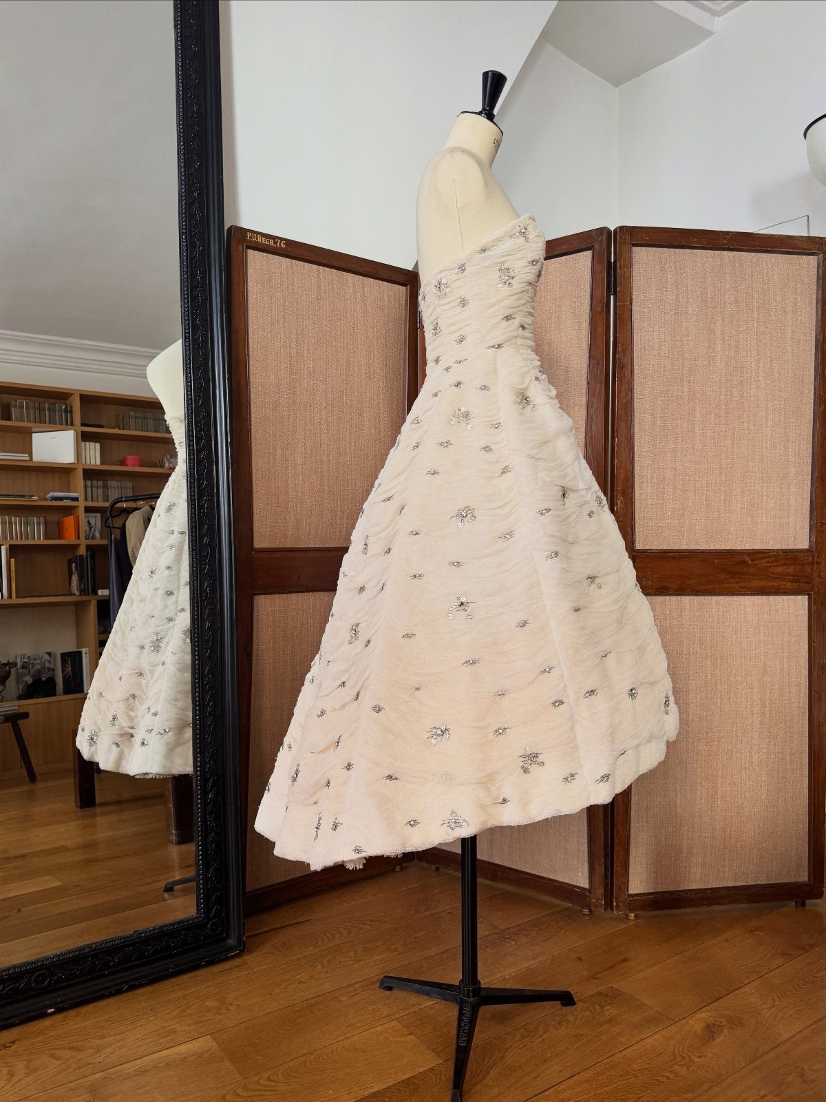 14 White Feather Gown Ideas, From Bridal Capes to Tea-Length 15 White strapless tea-length gown with feathers on a mannequin in a room