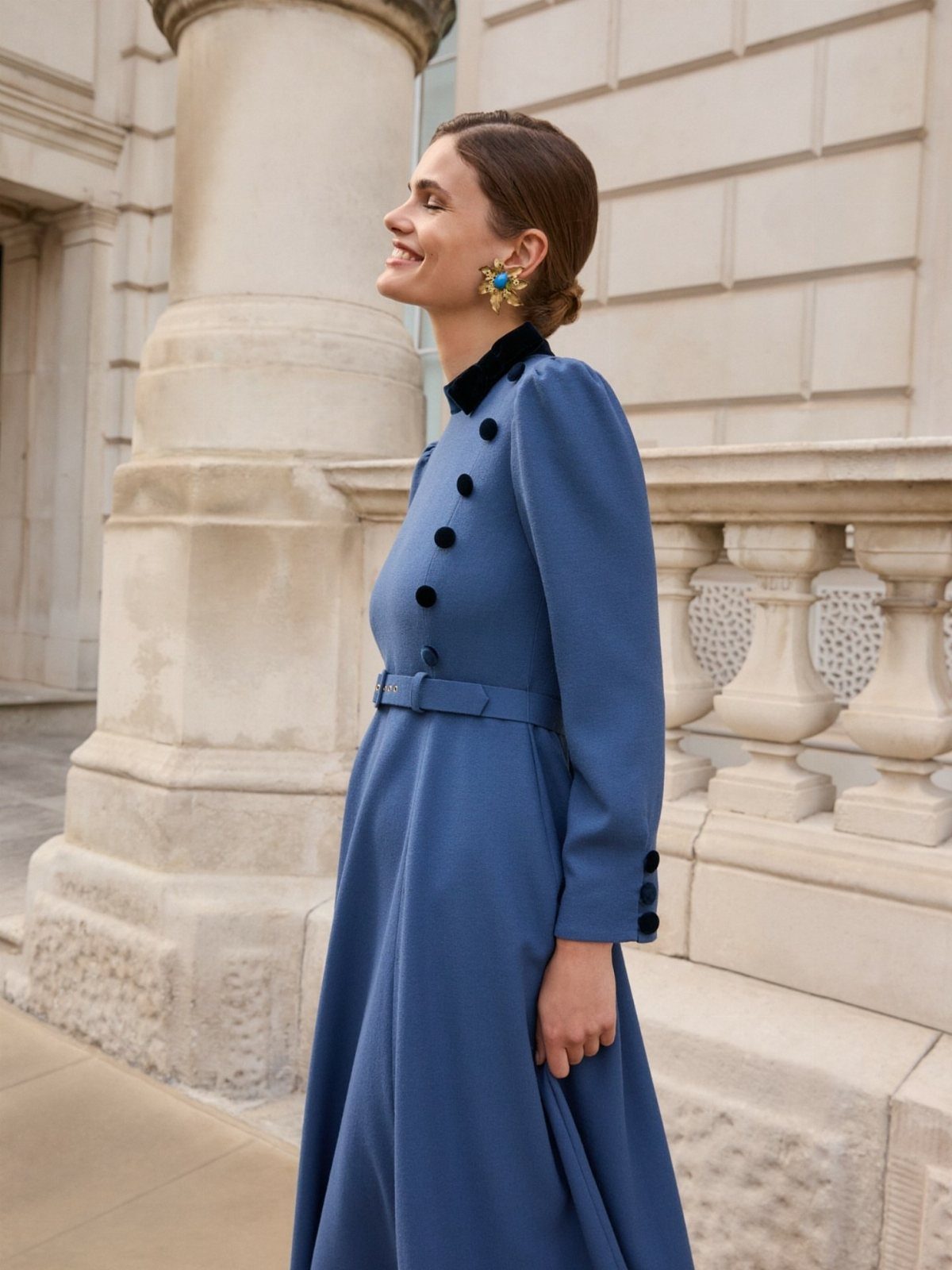 Woman wearing a long-sleeved blue winter dress with a black collar and buttons.