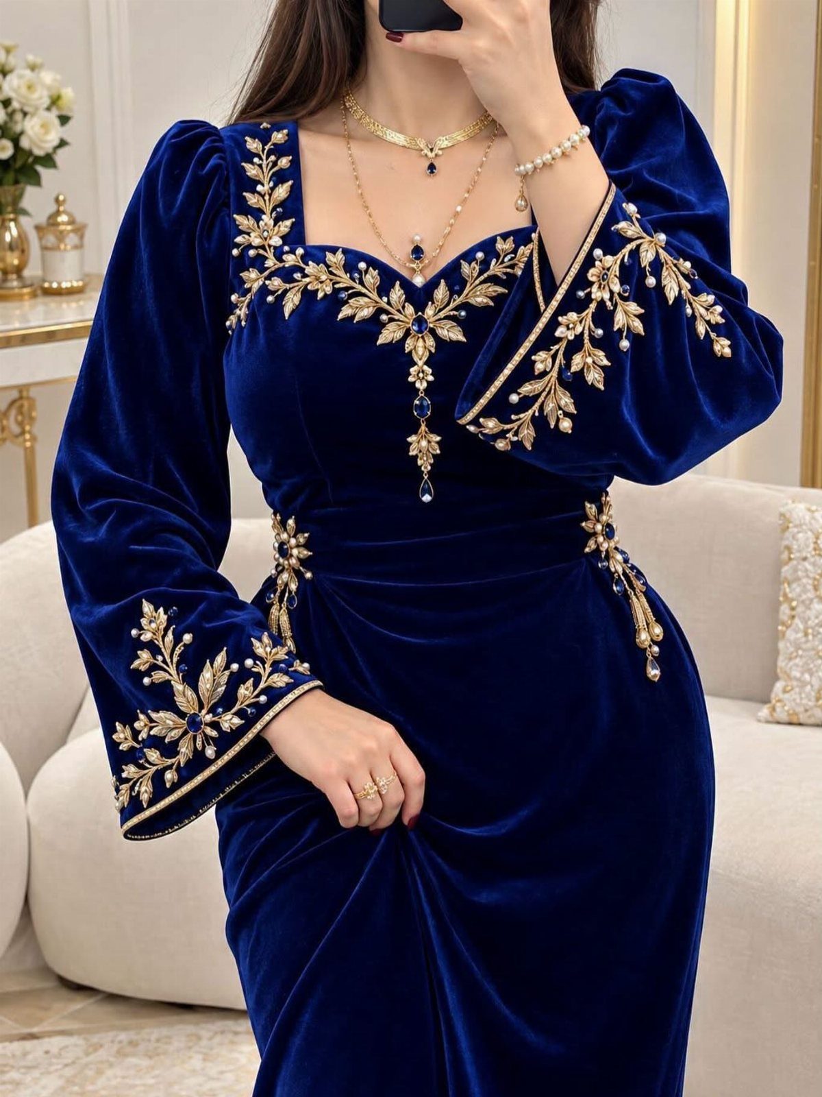 Royal blue velvet dress with gold floral embroidery and long puffed sleeves.