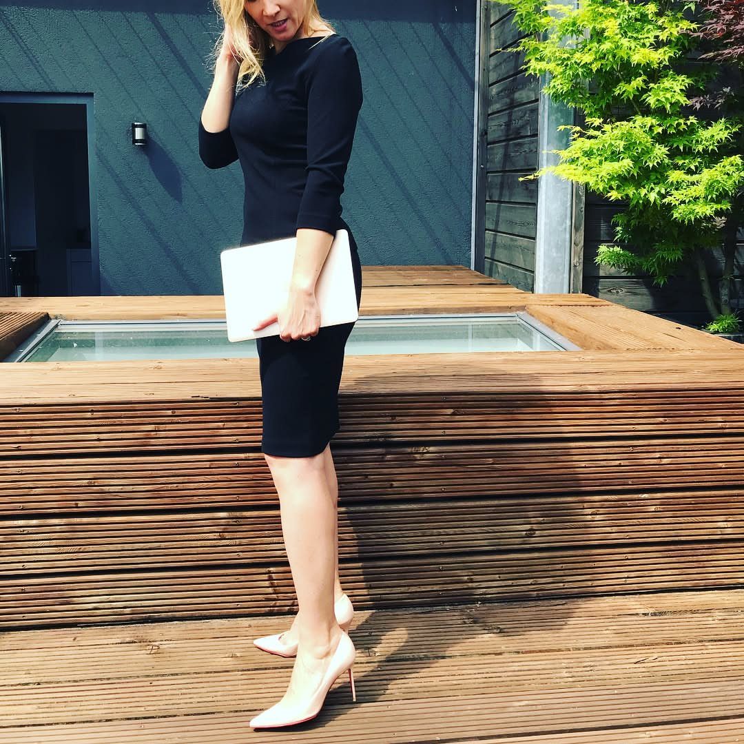 Women Outfit Work Office: 17 Ideas to Refresh Your Look 3 Woman in black sheath dress and high heels holding a white laptop outdoors.