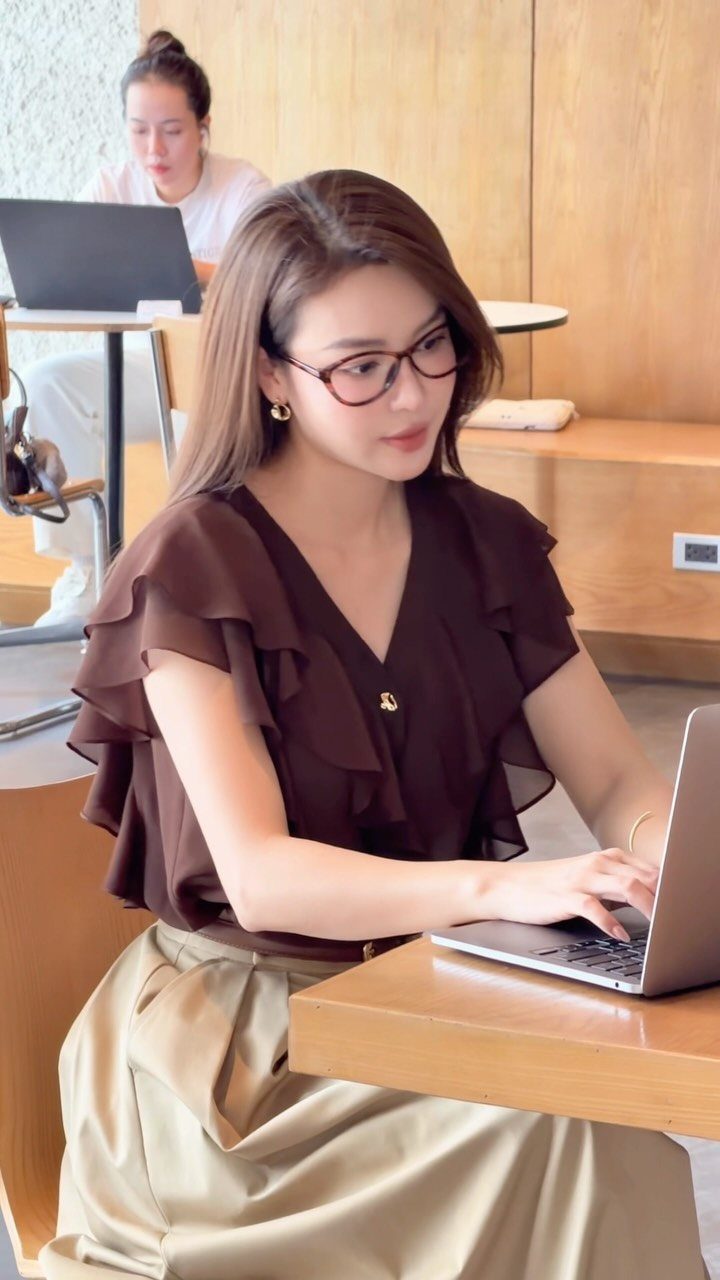 Women Outfit Work Office: 17 Ideas to Refresh Your Look 12 Woman in brown ruffled blouse and beige skirt working on a laptop at a table.